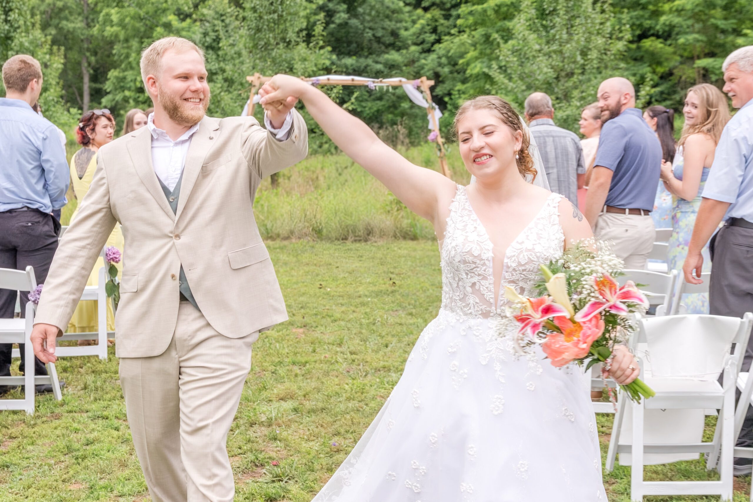 Bride and groom throw their hands up in celebration after saying I Do in front of their family and friends