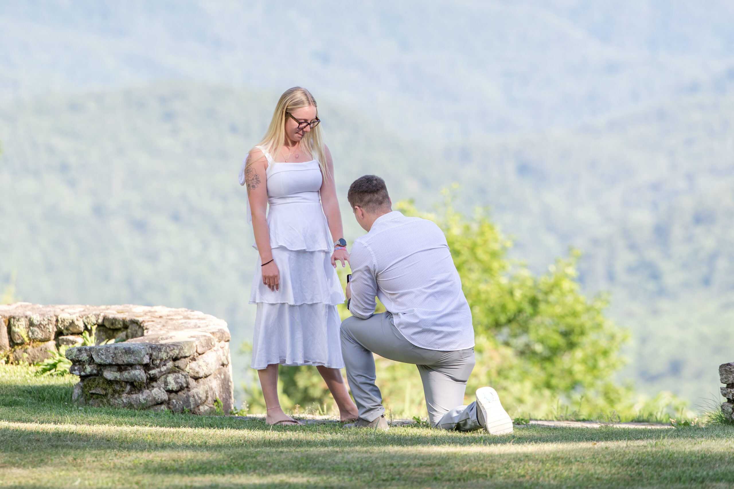 Man on one knee asking his long time love if she would marry him; captured as a surprise proposal